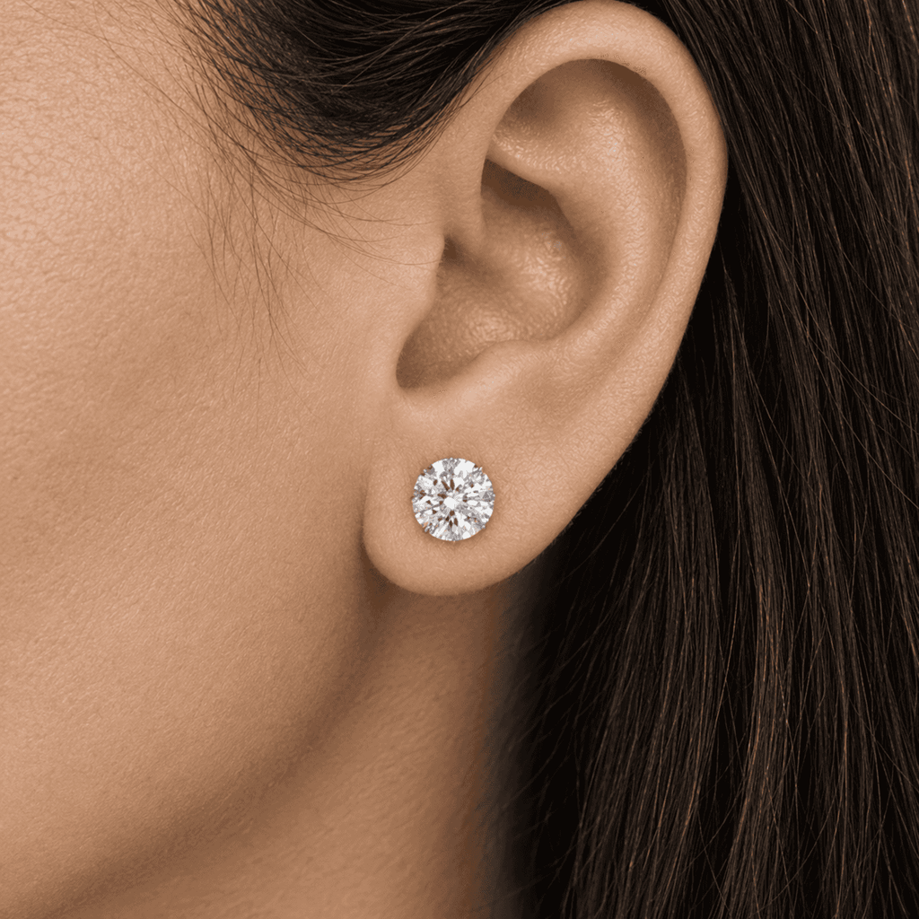 Classic round diamond stud earring worn on an ear by Gabriel Edward Jewelers