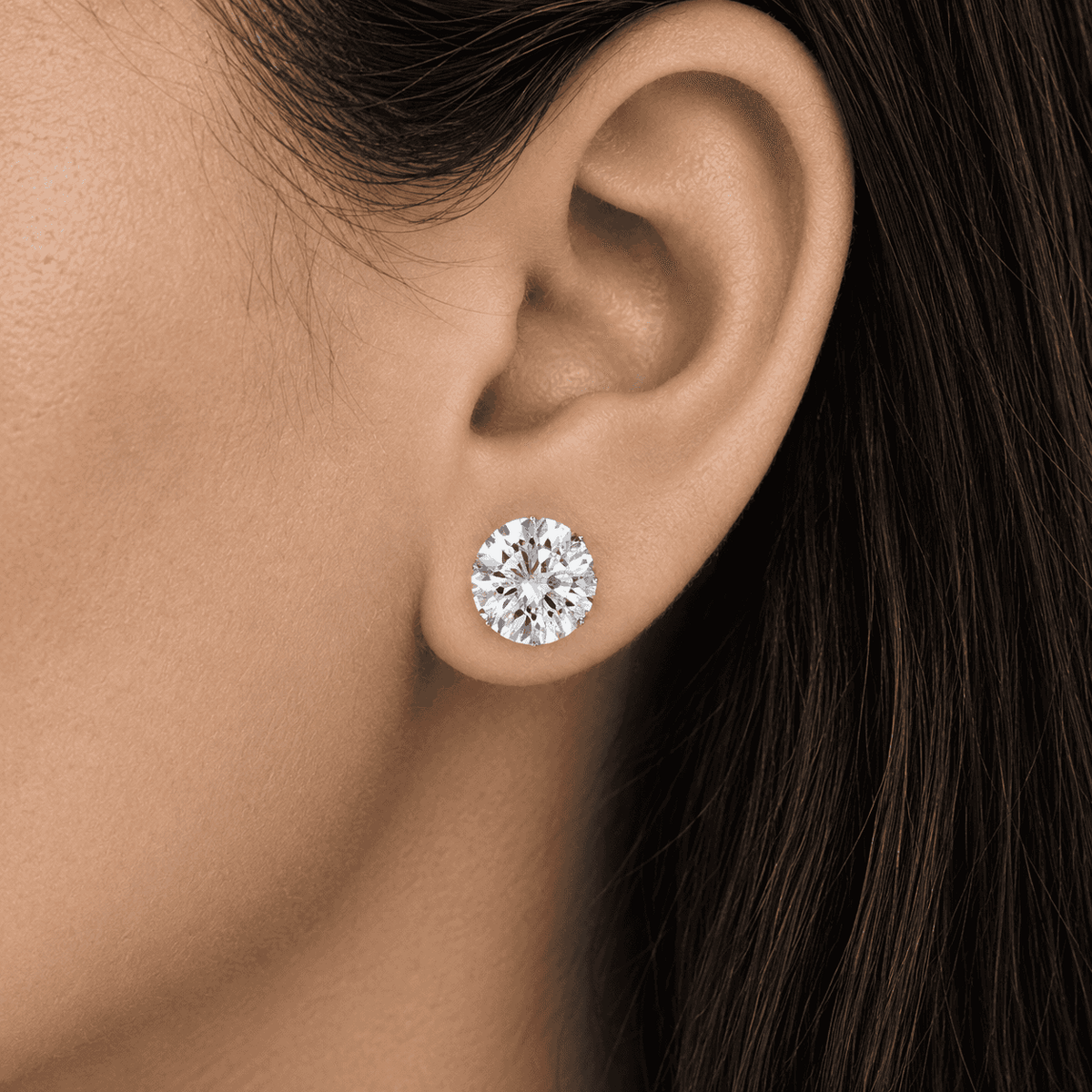 Round diamond stud earring worn on a woman's ear by Gabriel Edward Jewelers