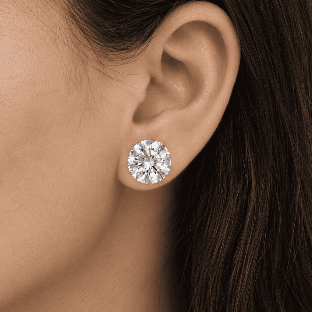 A round 9.5mm classic diamond stud earring worn on a woman's ear by Gabriel Edward Jewelers.