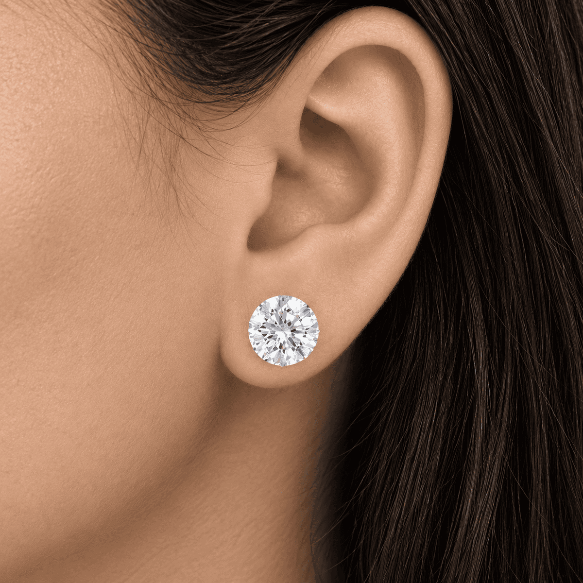 Round diamond stud earring worn on an ear by Gabriel Edward Jewelers