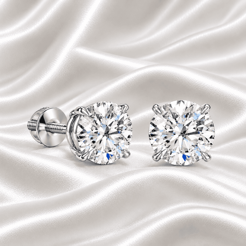 Pair of Gabriel Edward Jewelers classic round diamond stud earrings on white satin fabric