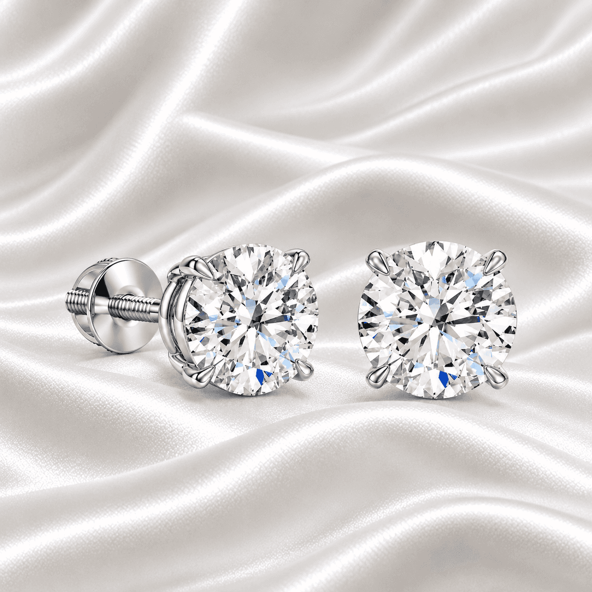 Pair of Gabriel Edward Jewelers classic round diamond stud earrings on white satin fabric