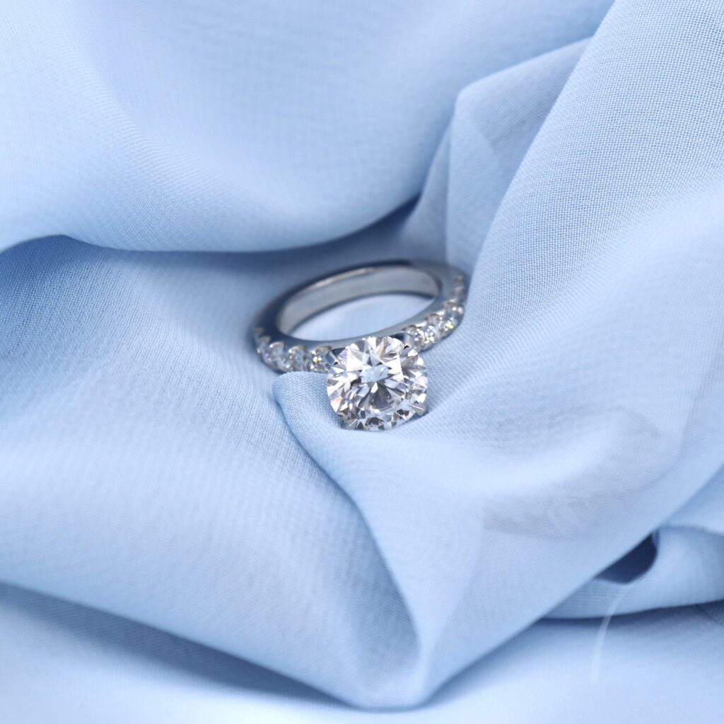 A gorgeous Round Diamond Engagement Ring with a 4.25 carat IGI graded Center Diamond on a 14kt White Gold Setting with 3 mm Diamonds on the band.