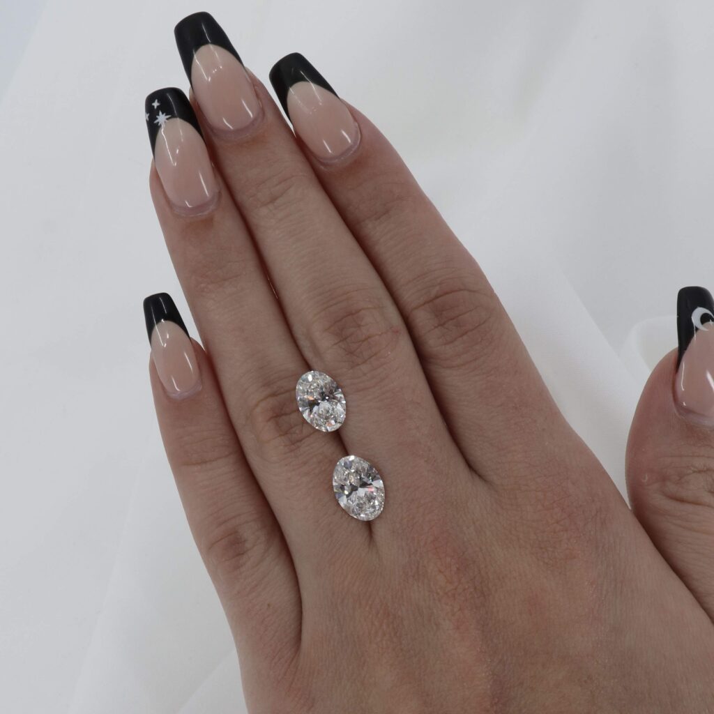 An "Excellent" Cut 2.69 carat Oval Diamond and a 2.31 carat Oval Diamond with "Very Good" proportions. Both F Color, but the 2.69 carat is noticeably brighter.
